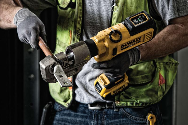 Una persona con guantes y un chaleco de seguridad verde está utilizando una herramienta amarilla inalámbrica DEWALT para crimpar o cortar una tubería metálica.