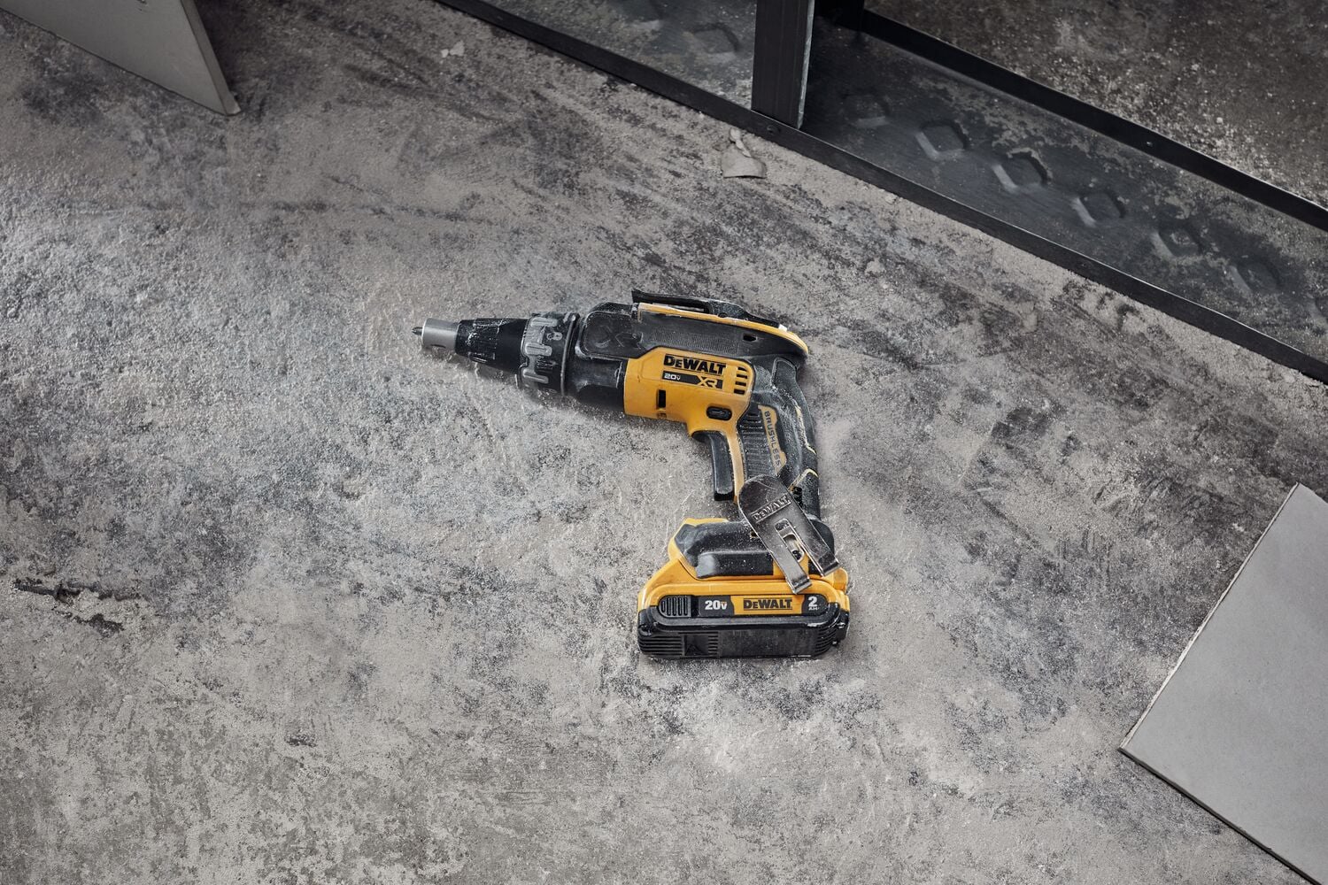 Drywall screwgun and cutout tool on floor in commercial setting