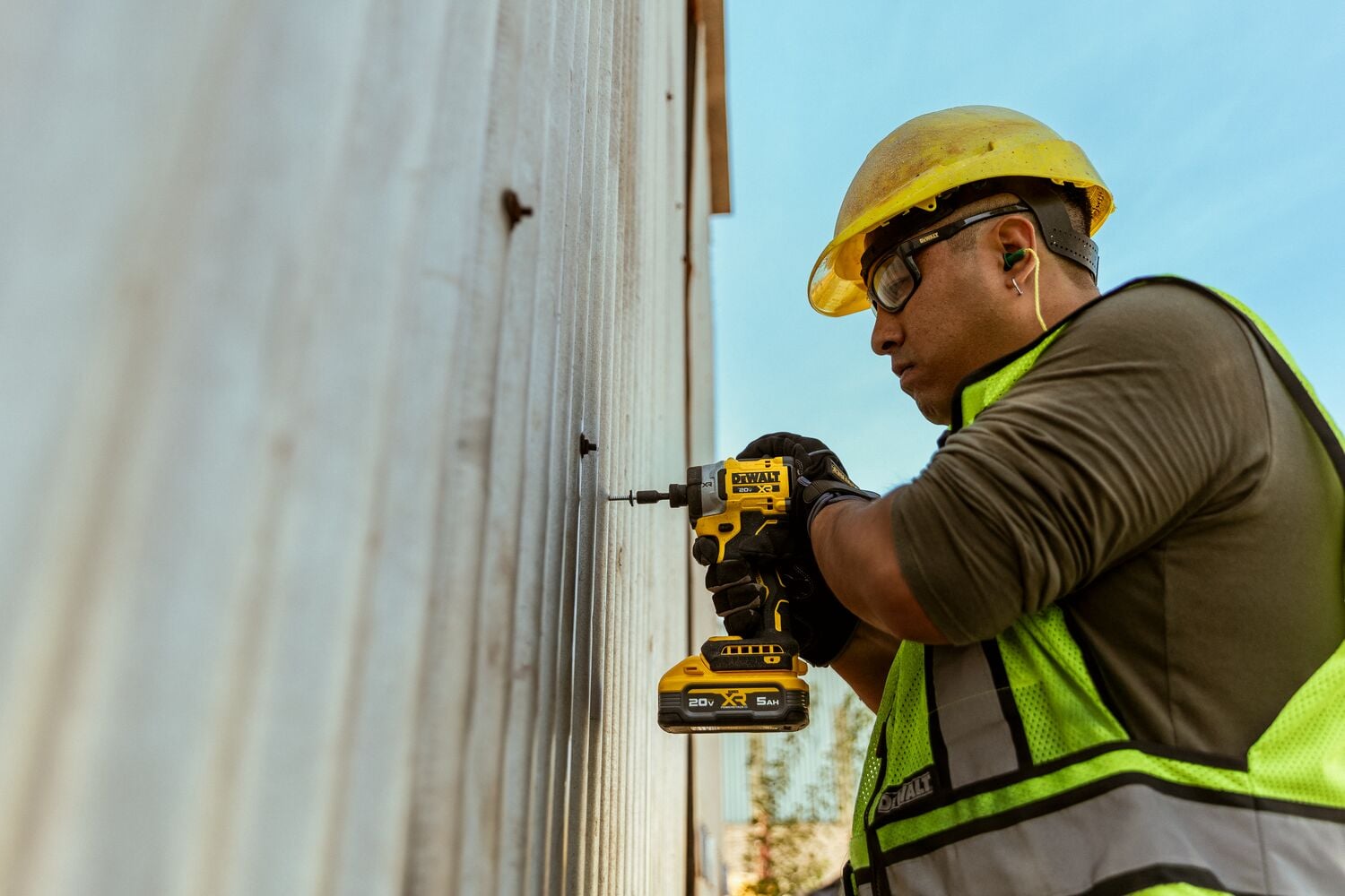 Batería XR POWERSTACK 5 AH en la mano de un trabajador en un entorno de obra de construcción