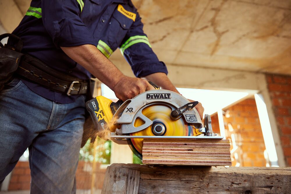 Trabajador usando sierra circular DCS570 cortando madera