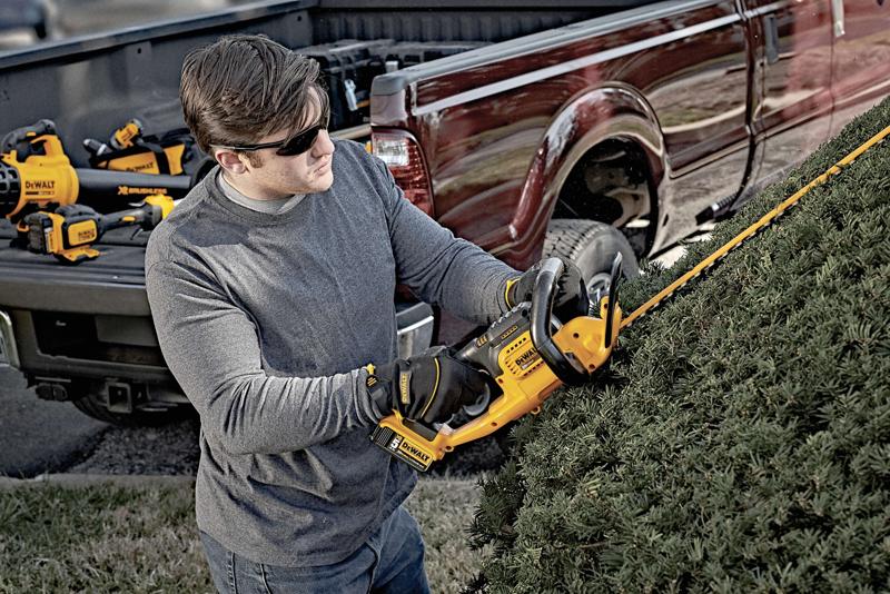 Lithium ion hedge trimmer being used by a person
