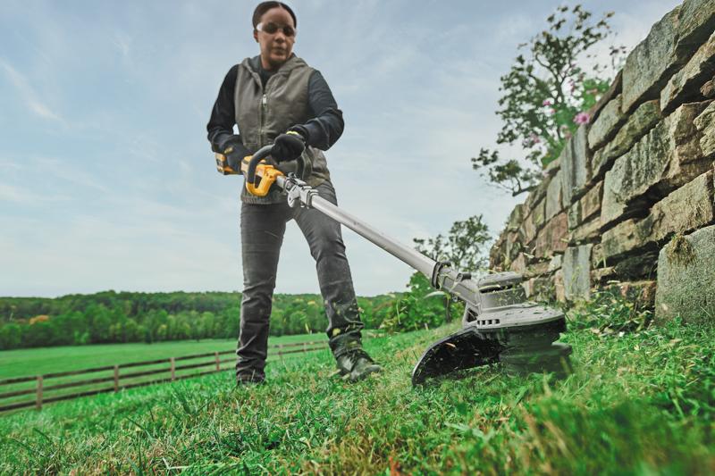 low angle view of Folding String Trimmer being used by person on grass.