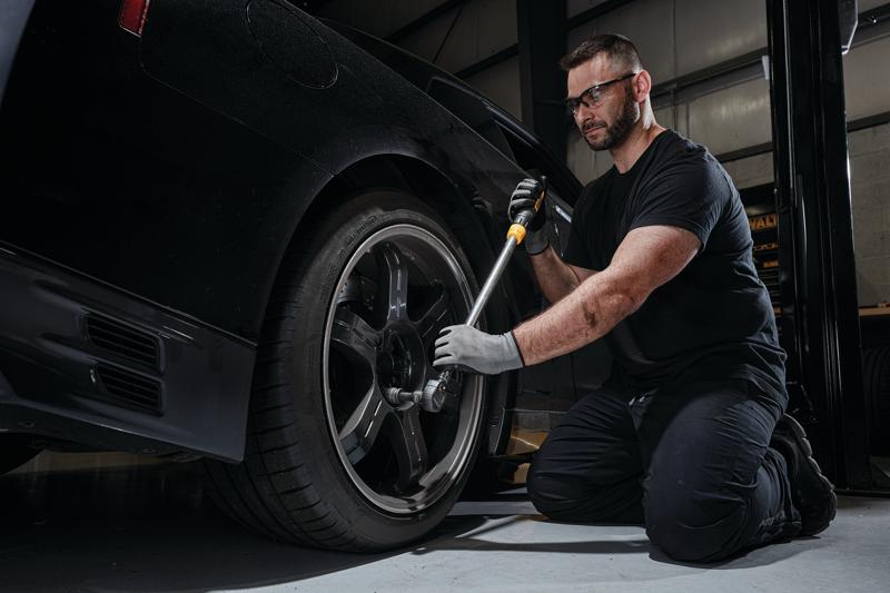 Drive torque wrench tire change kit being used to change tire.