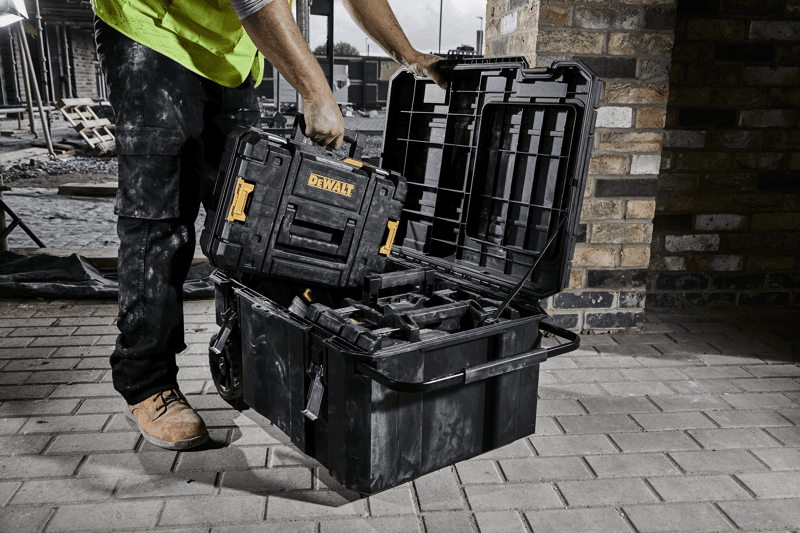Construction worker pulling a TSTAK case from an open TSTAK job chest