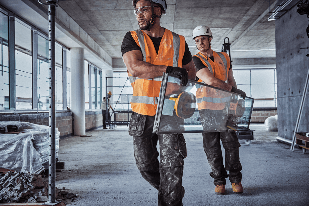 Users carrying glass panel with DEWALT 20V MAX Grabo Lifter