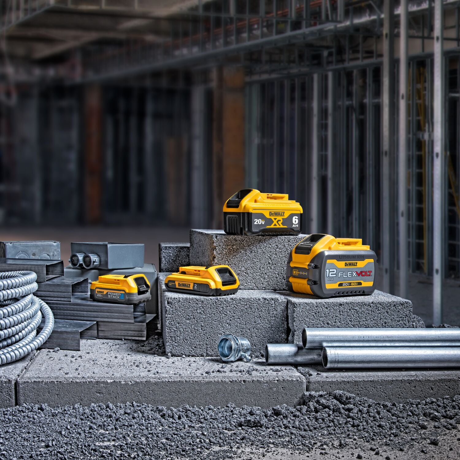 Varias baterías de ion de litio DEWALT están expuestas sobre bloques de concreto en un sitio de construcción, incluyendo una batería 20V XR y una batería 12V FLEXVOLT, rodeadas de tubos de metal y materiales de construcción.