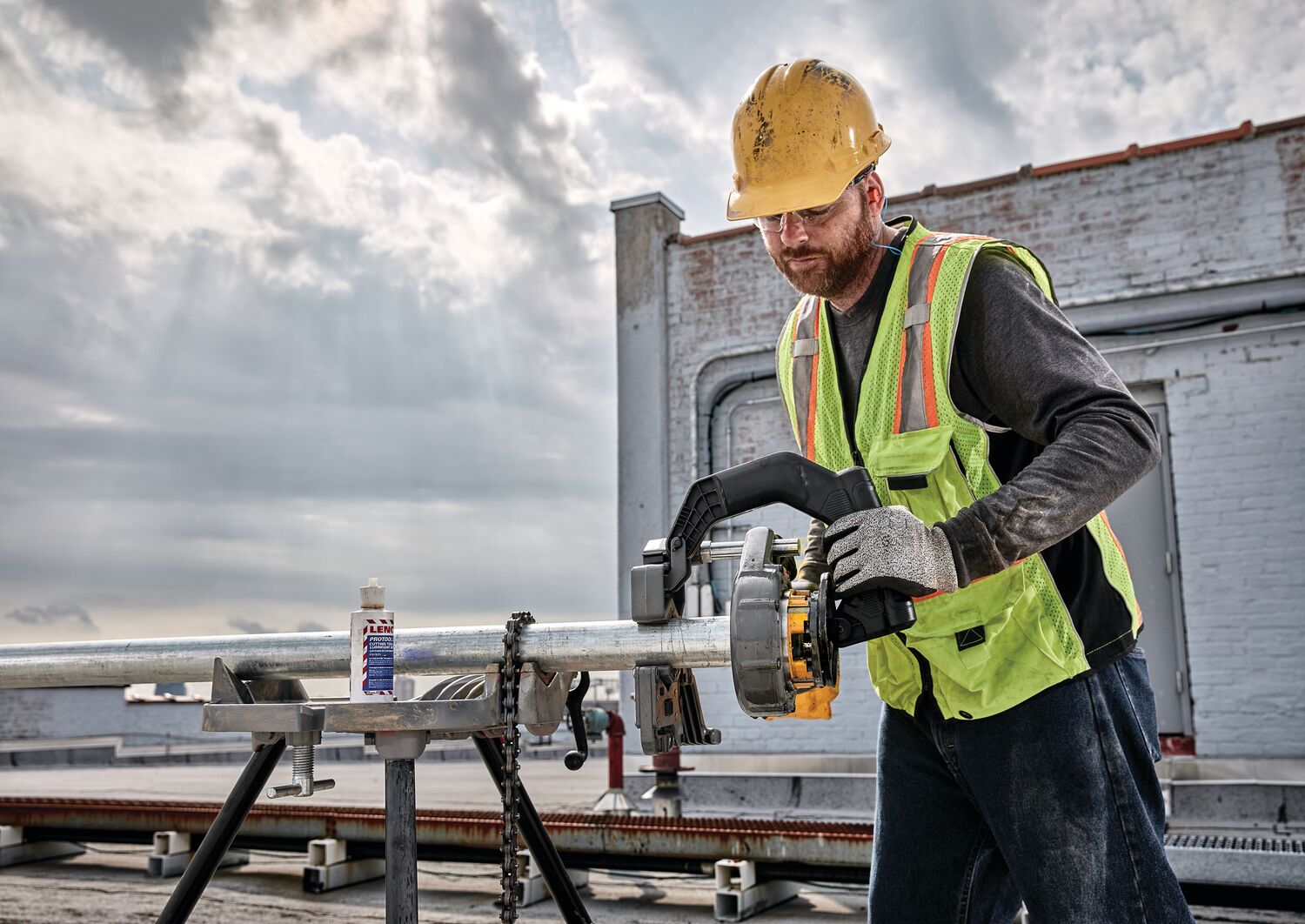 FLEXVOLT cordless pipe threader being used by person on steel pipe.